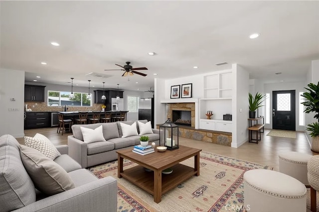2485 W Westward Ave, Banning, CA 92220 - living area with recessed lighting, ceiling fan, a fireplace with raised hearth, and built in shelves