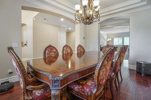 dining room featuring crown molding, baseboards, a chandelier, hardwood / wood-style flooring, and arched walkways