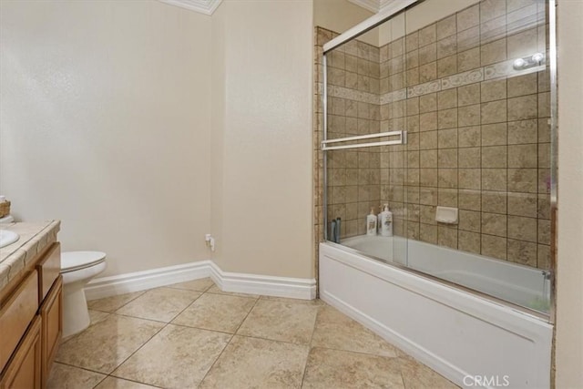 bathroom featuring vanity, toilet, shower / bath combination with glass door, baseboards, and tile patterned floors