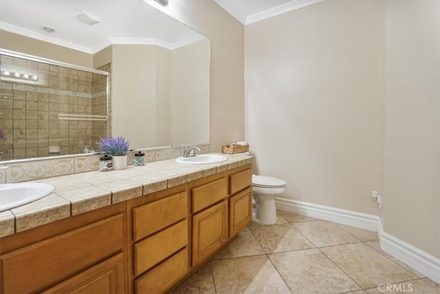 bathroom with a sink, toilet, ornamental molding, and tiled shower