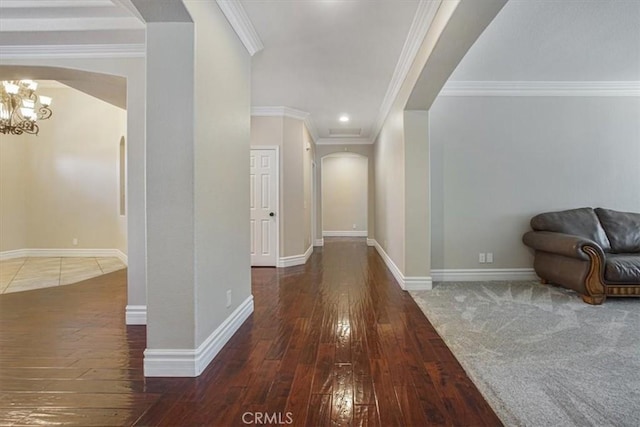 hallway featuring baseboards, arched walkways, a chandelier, and hardwood / wood-style floors