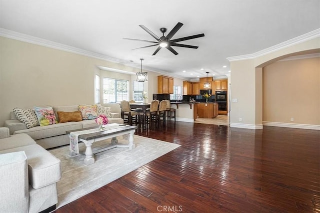 living room with crown molding, arched walkways, ceiling fan, and recessed lighting