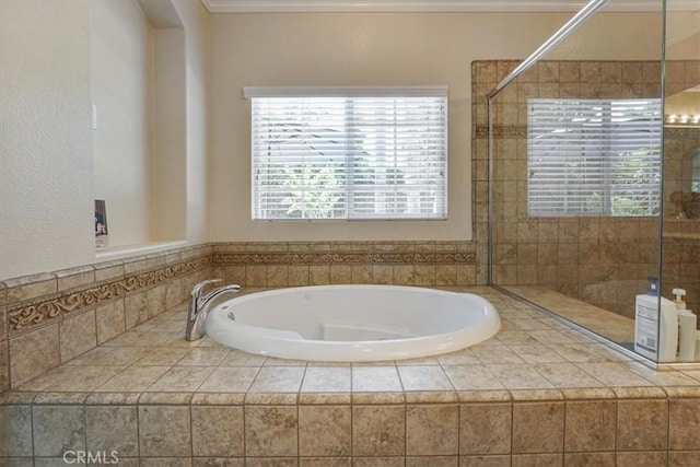 full bathroom with ornamental molding, a bath, and tiled shower