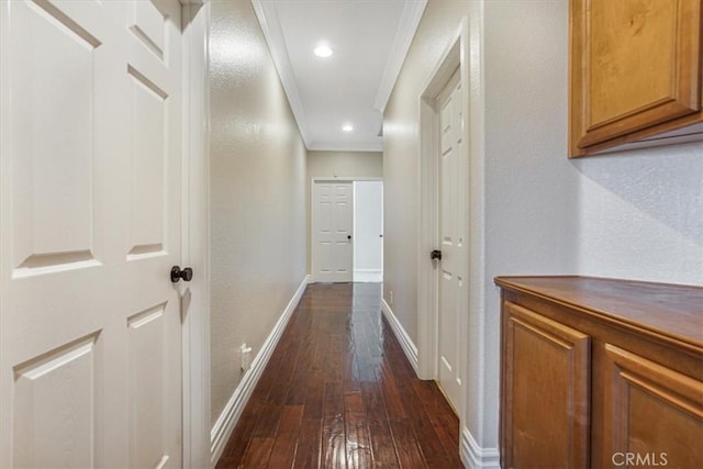 corridor featuring crown molding, baseboards, a textured wall, recessed lighting, and dark wood-type flooring