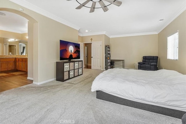 bedroom with arched walkways, baseboards, light colored carpet, and ornamental molding