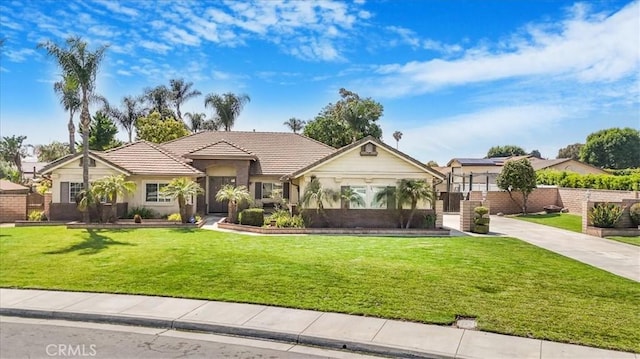 ranch-style home featuring a tiled roof, a front lawn, stucco siding, and driveway