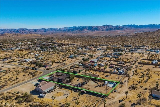 4796 Camarilla Ave, Yucca Valley, CA 92284 - aerial perspective of suburban area with mountains, a desert landscape, and property boundaries highlighted
