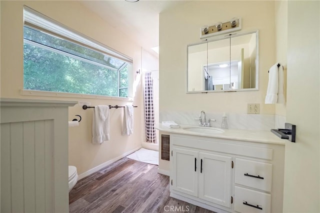 full bathroom with vanity, baseboards, toilet, and wood finished floors