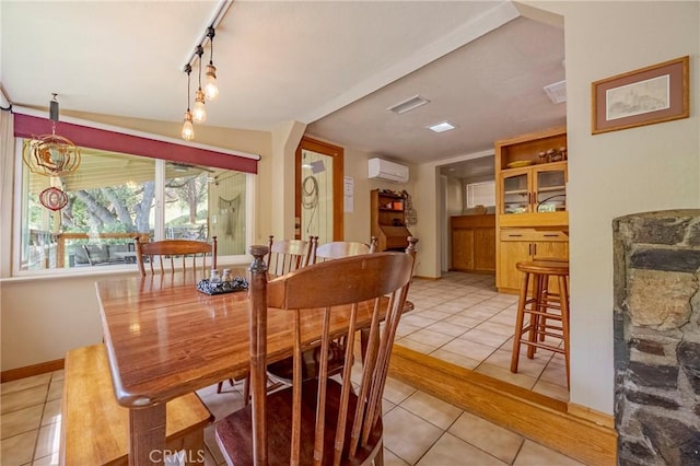 dining space featuring an AC wall unit, baseboards, light tile patterned flooring, and visible vents