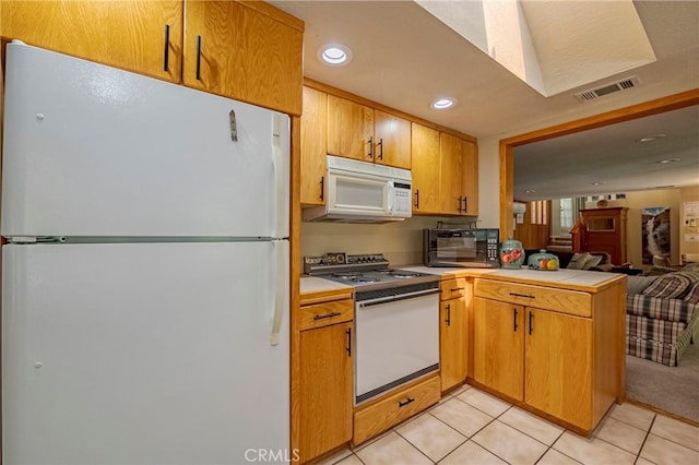 kitchen featuring visible vents, light countertops, a peninsula, open floor plan, and white appliances