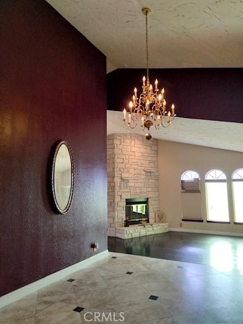 unfurnished living room with baseboards, a fireplace, high vaulted ceiling, and a chandelier