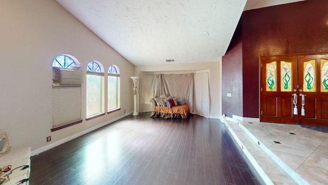 interior space featuring visible vents, wood finished floors, and high vaulted ceiling