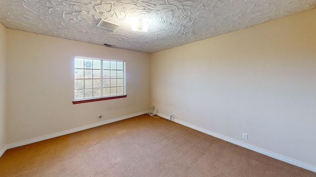 unfurnished room featuring baseboards, carpet flooring, and visible vents
