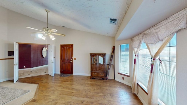 entryway with a healthy amount of sunlight, baseboards, and lofted ceiling