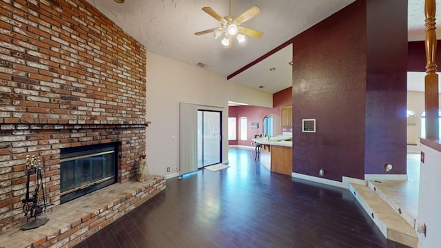 unfurnished living room with ceiling fan, a fireplace, wood finished floors, baseboards, and high vaulted ceiling