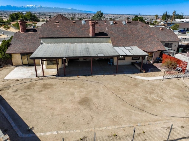 townhome / multi-family property with a residential view, fence, a chimney, and a mountain view