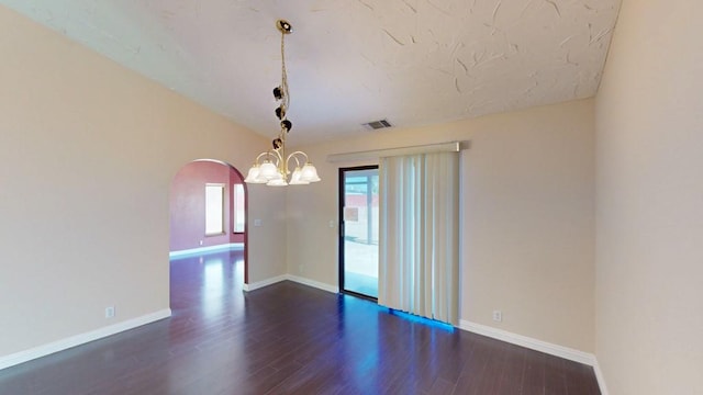 unfurnished room with visible vents, dark wood-style flooring, baseboards, a chandelier, and arched walkways