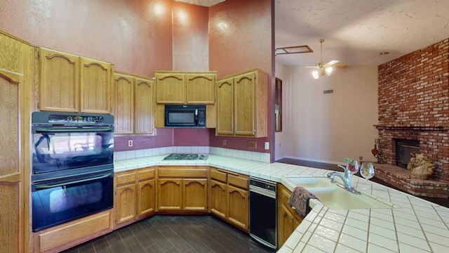 kitchen featuring tile counters, ceiling fan, a sink, and black appliances