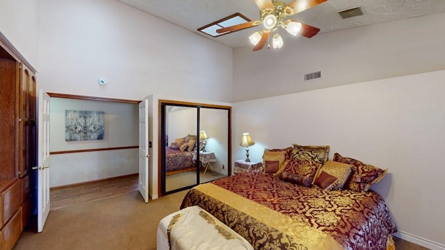 bedroom featuring ceiling fan, light colored carpet, high vaulted ceiling, baseboards, and visible vents