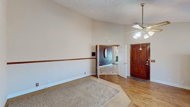 empty room with ceiling fan, a textured ceiling, visible vents, wood finished floors, and baseboards