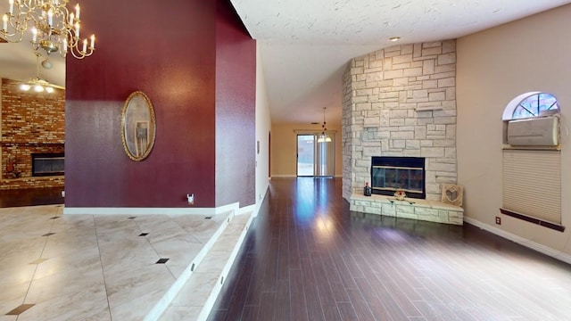 unfurnished living room with an inviting chandelier, baseboards, a stone fireplace, and lofted ceiling