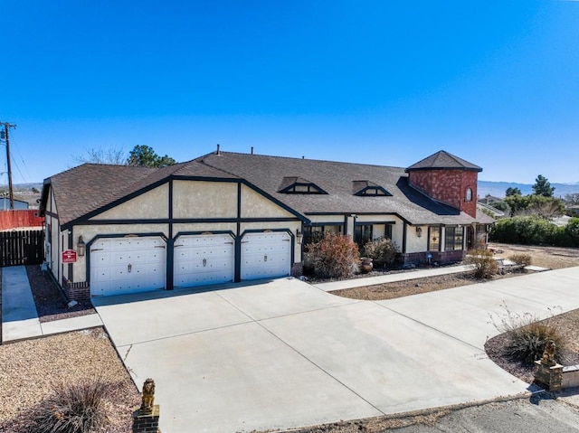 view of front of property with driveway, fence, an attached garage, a shingled roof, and stucco siding