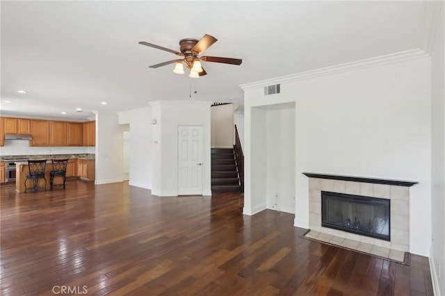 12851 Oakdale St, Eastvale, CA 92880 - unfurnished living room featuring dark wood-type flooring, ceiling fan, stairs, recessed lighting, and crown molding
