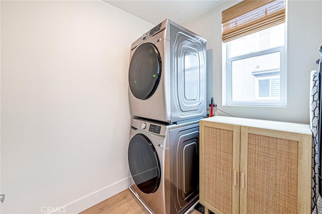 11751 Florence Ave, Santa Fe Springs, CA 90670 - clothes washing area featuring laundry area, stacked washer and clothes dryer, light wood finished floors, and baseboards