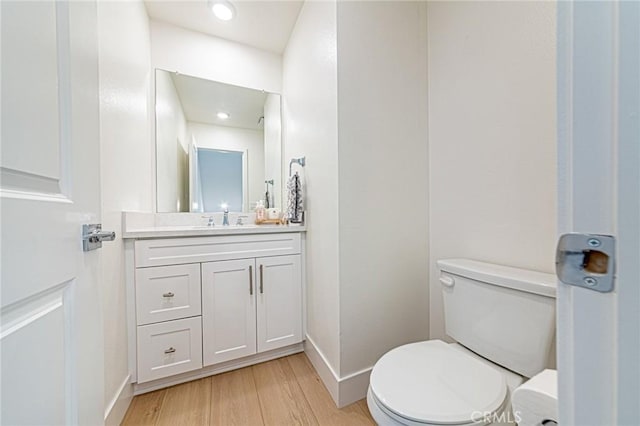 11751 Florence Ave, Santa Fe Springs, CA 90670 - bathroom with baseboards, wood finished floors, toilet, and vanity