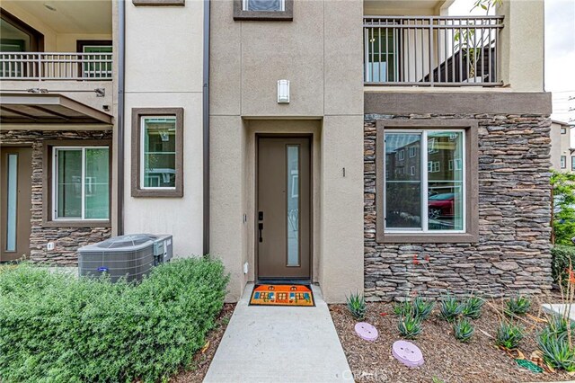 11751 Florence Ave, Santa Fe Springs, CA 90670 - property entrance with a balcony, stone siding, and stucco siding