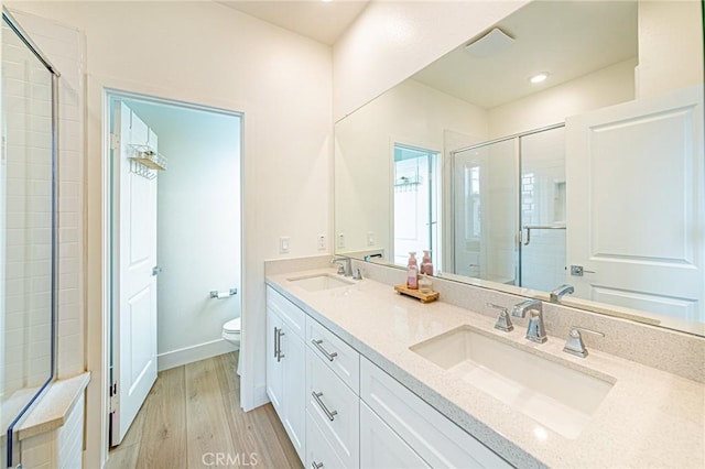 11751 Florence Ave, Santa Fe Springs, CA 90670 - bathroom with wood finished floors, a sink, a stall shower, and toilet
