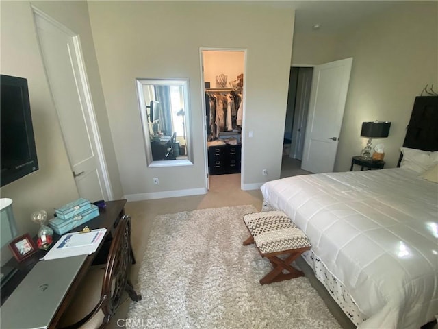 carpeted bedroom with baseboards, a spacious closet, and a closet