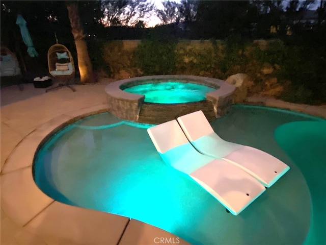 view of pool featuring a pool with connected hot tub and a patio area