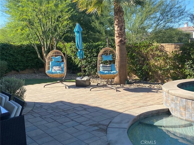 view of patio with an in ground hot tub and a fenced backyard