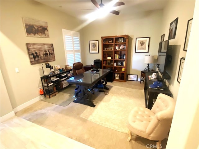 carpeted office featuring ceiling fan and baseboards