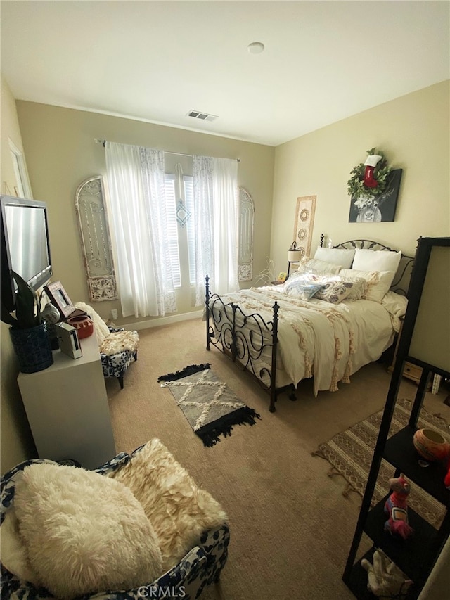 carpeted bedroom featuring visible vents