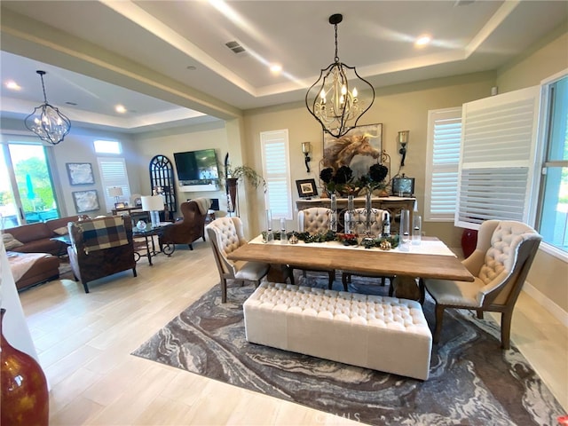 dining area with an inviting chandelier, visible vents, wood finished floors, recessed lighting, and a raised ceiling