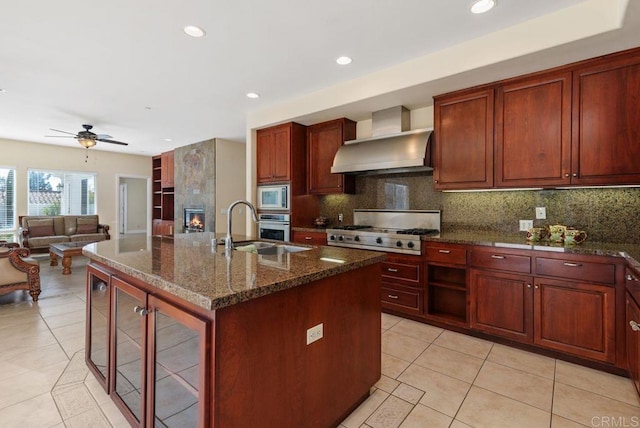 kitchen with a sink, decorative backsplash, stainless steel appliances, and wall chimney exhaust hood
