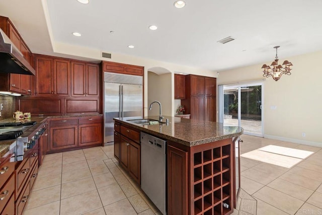 kitchen with visible vents, wall chimney exhaust hood, a sink, light tile patterned floors, and stainless steel appliances