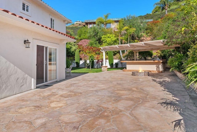 view of patio / terrace with a pergola and a fire pit