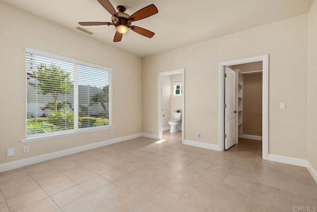 unfurnished bedroom with visible vents, connected bathroom, baseboards, and a spacious closet
