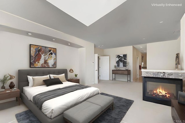bedroom featuring recessed lighting, a warm lit fireplace, and light colored carpet