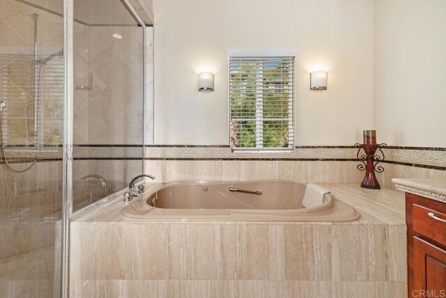 bathroom with vanity, a bath, and a shower stall