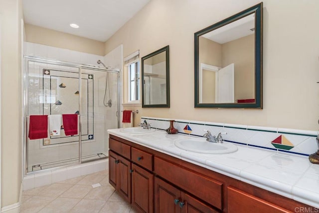 bathroom featuring a sink, tile patterned flooring, and a stall shower