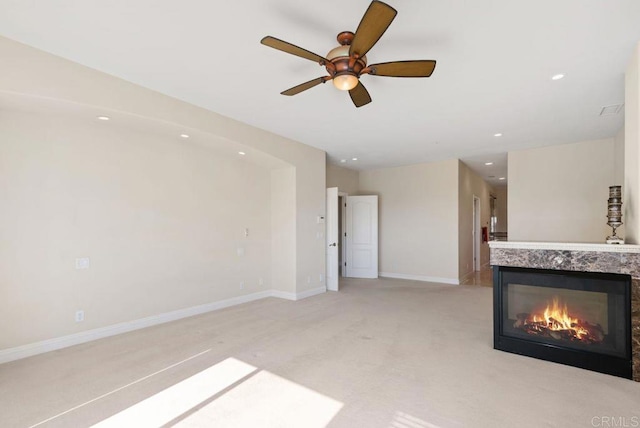 unfurnished living room with ceiling fan, light colored carpet, a fireplace, baseboards, and recessed lighting