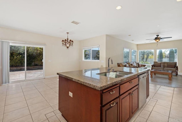 kitchen with a sink, light tile patterned floors, a healthy amount of sunlight, and dishwasher