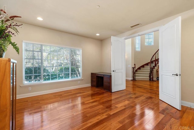 interior space featuring visible vents, light wood-type flooring, stairs, baseboards, and recessed lighting