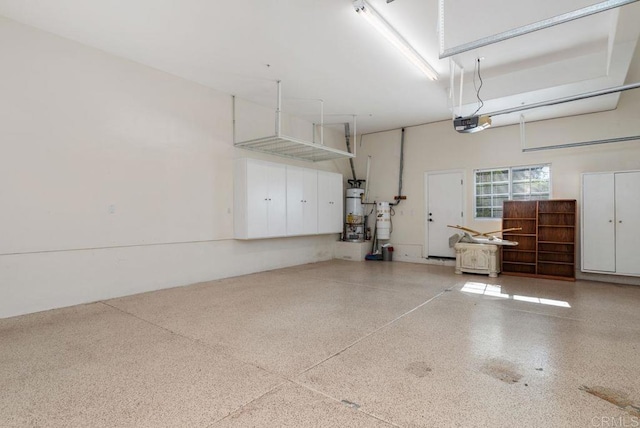 garage featuring strapped water heater and a garage door opener