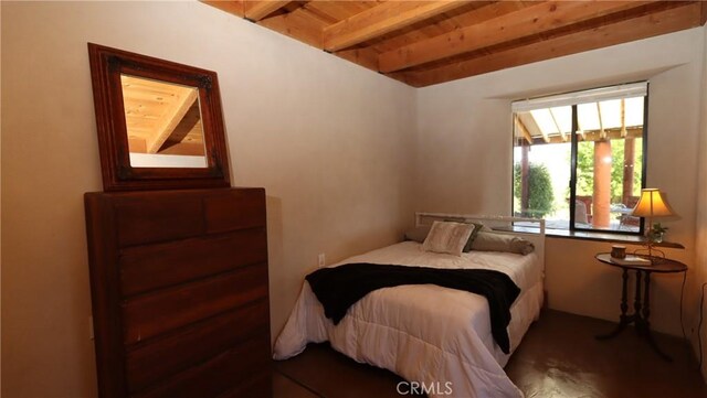 bedroom featuring wood ceiling with exposed beams