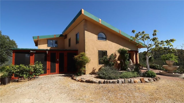 view of side of home with french doors and stucco siding
